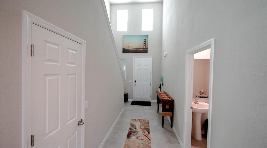 Storage under the stairs on the left, 1/2 bath on the right, and the two-story entryway straight ahead with multiple windows lets in the wonderful natural light!