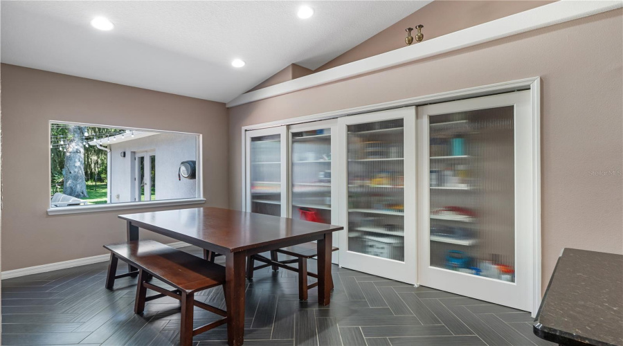The kitchen-to-table connection is seamless in this chef’s kitchen, where an inviting dining space flows effortlessly from the heart of the home. Featuring herringbone tile floors, exceptional pantry storage, and a thoughtfully designed layout, this space is perfect for everyday living and effortless entertaining.