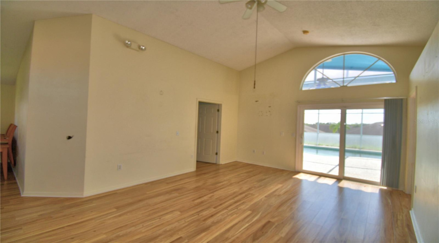 Living room with arched transom window and sliding glass door creates a brighter room.
