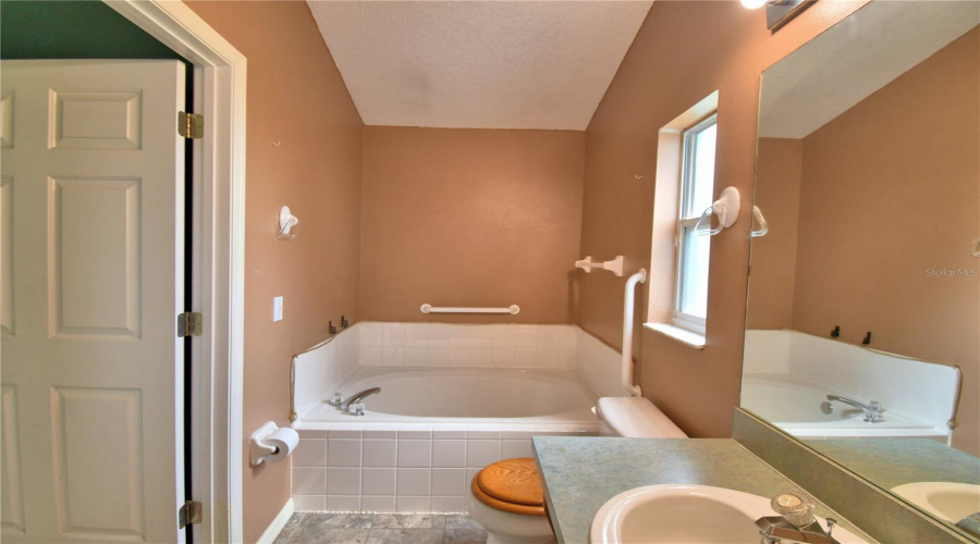 The Primary bath is equipped with grab bars around the tub