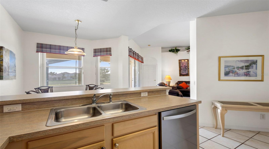 Kitchen sink view overlooking dining area and pool