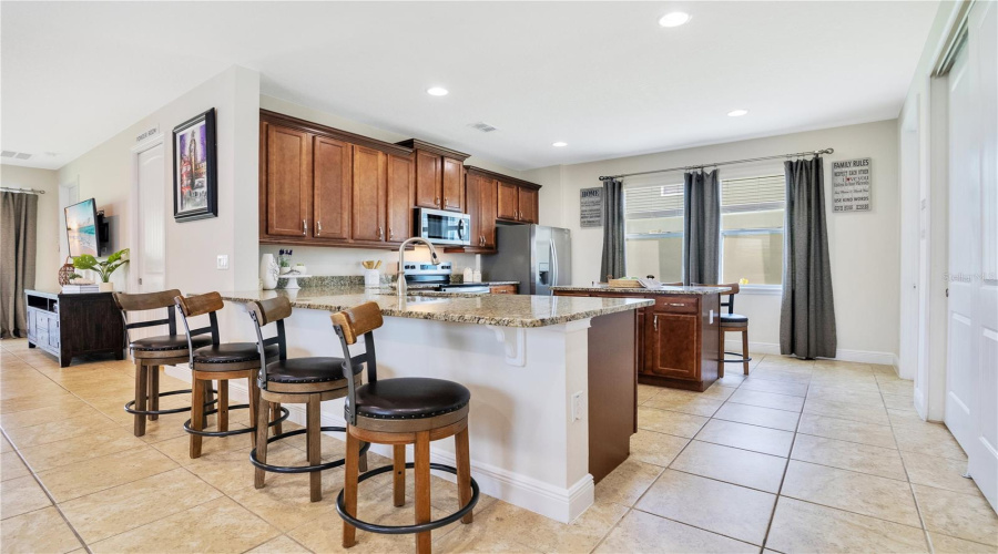 A Chef's Kitchen with Granite Counters and Breakfast Bar with Ample Seating