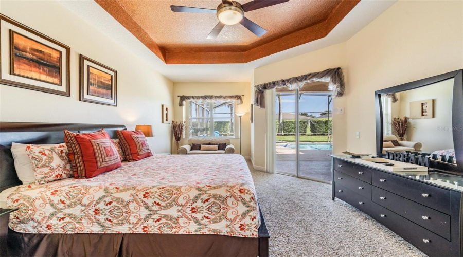 Large primary bedroom features a cozy seating area, perfect for reading or accommodating extra guests and offers direct access to the pool and spa.