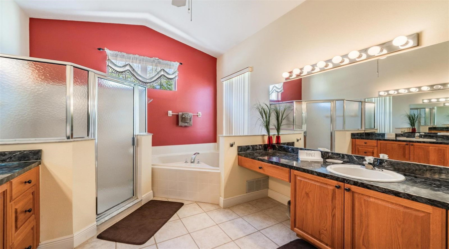 The primary bath features a soaking tub, separate shower, and dual sinks, offering comfort and convenience for a spa-like experience.