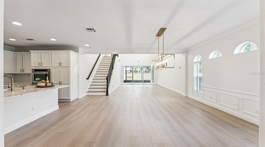 Spacious open-concept living area with modern finishes, natural light, and seamless flow to the kitchen and patio.