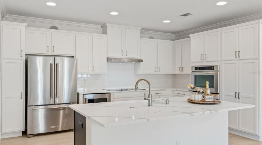 Recently renovated kitchen features double built-in ovens, wine/beverage fridge, stylish finishes, and a large island.