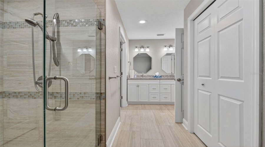 Primary Bathroom: Contemporary en-suite bath with walk-in shower and upgraded finishes.