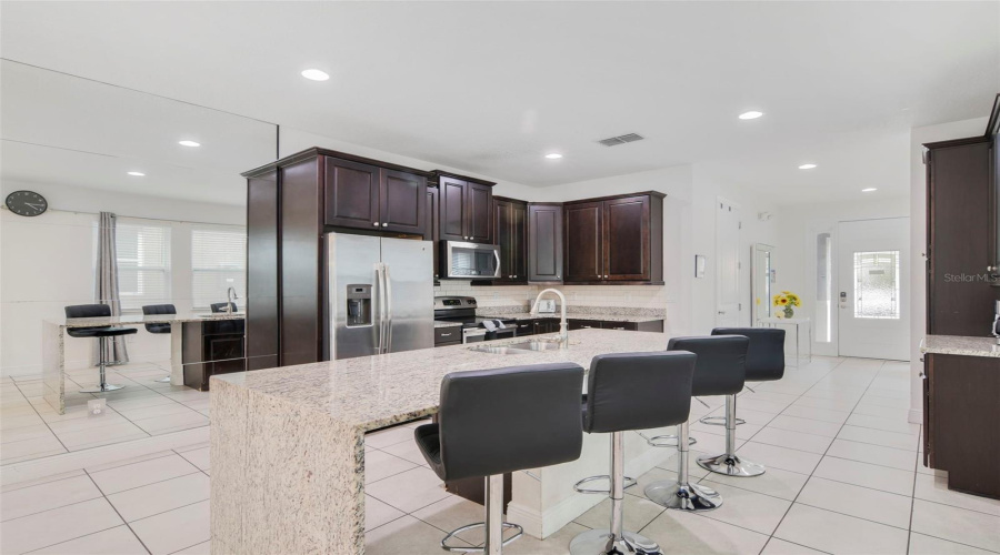 Step inside to a bright and spacious OPEN-CONCEPT design where the Kitchen, Dining, and Living areas flow seamlessly together, all overlooking the HEATED FRESHWATER POOL, SPA and private patio.