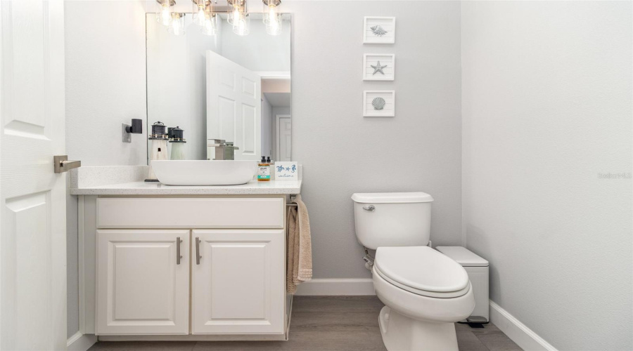 Downstairs half bathroom with NEW quartz countertops, sink, faucet and lighting!