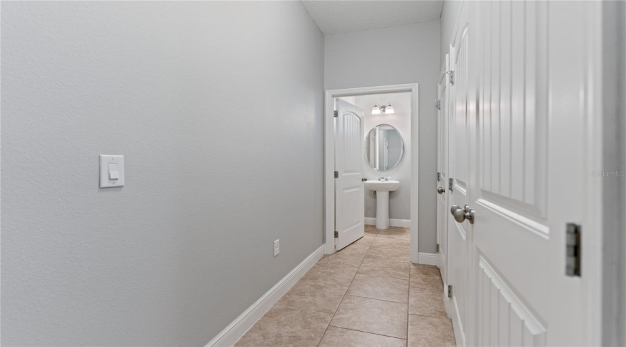 hallway to garage, half bath, and laundry