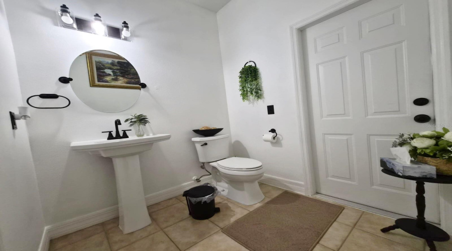 Downstairs half bath with access to the pool and the interior.