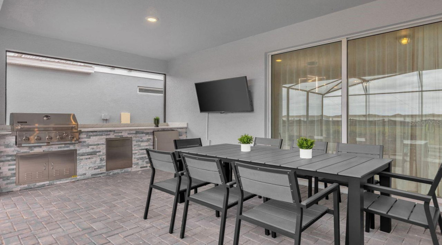 Outdoor - Covered patio with dining table, summer kitchen and conversation set