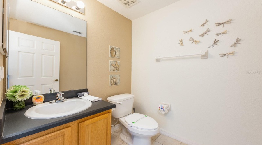 A stylish half bath and laundry room on the first floor serve guests and pool users with ease.