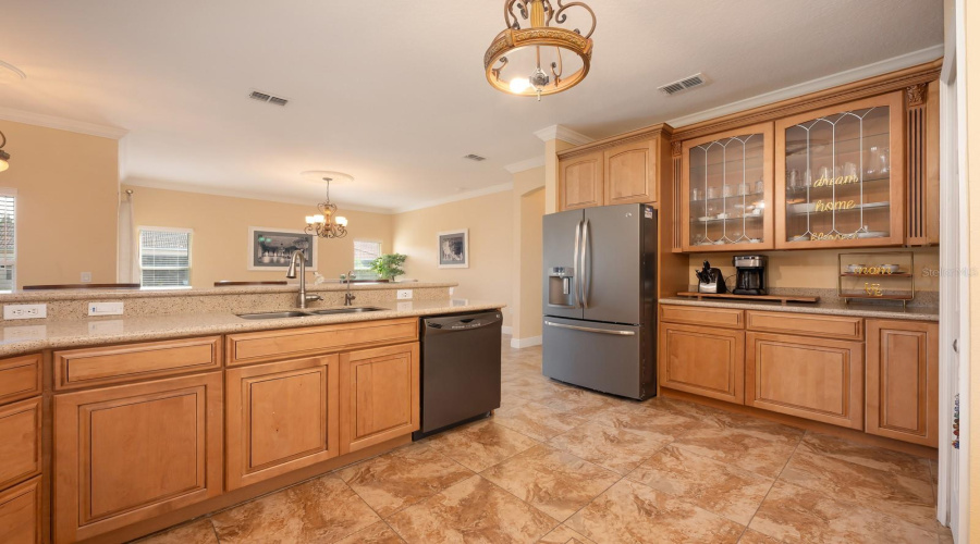 The kitchen sits at the heart of the home and features solid wood cabinetry, a breakfast bar, pantry storage, and a connected layout that opens to the main living areas – perfect for entertaining or casual everyday living!