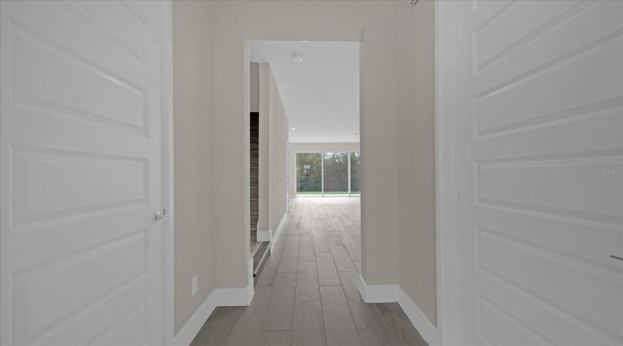 hallway at entry into open kitchen, living, and dining