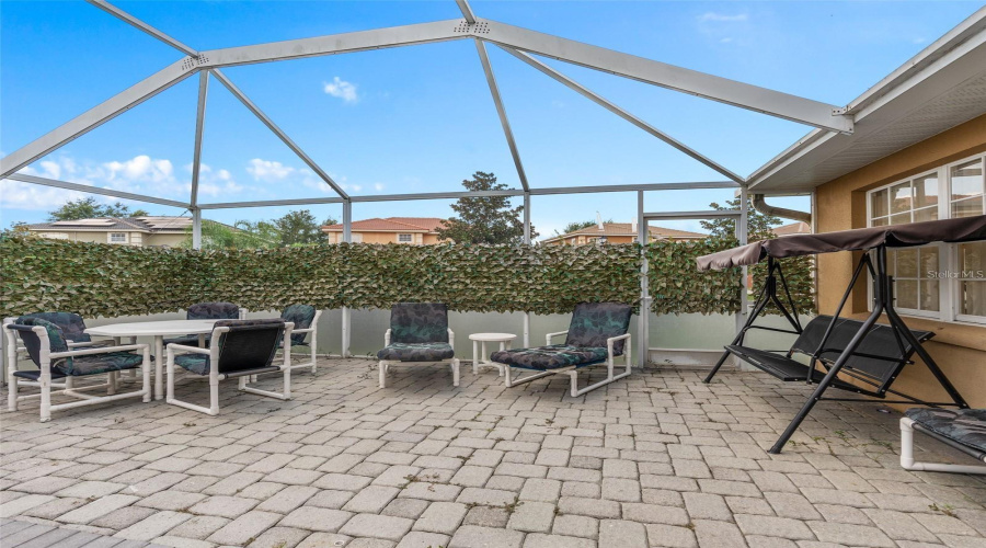 Extended paver patio overlooks the screened pool.