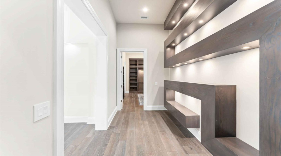 Striking statement shelving hallway leads to two more tastefully themed ensuites..