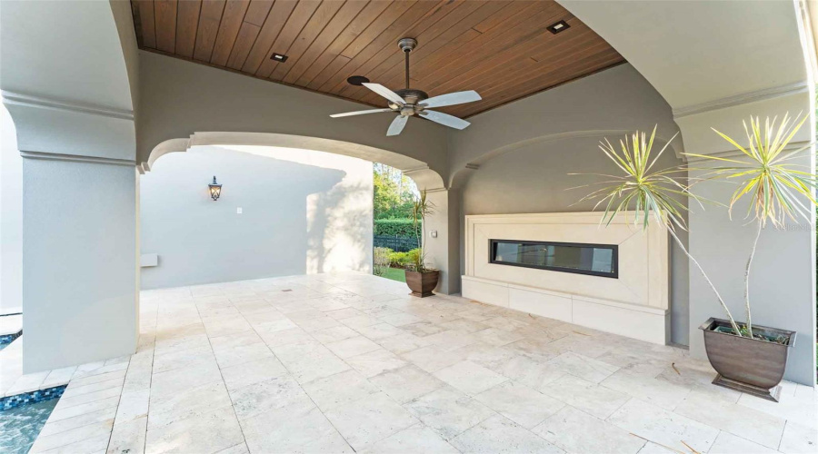 Outdoor fireplace by the water curtain. Perfect for our Florida evenings..