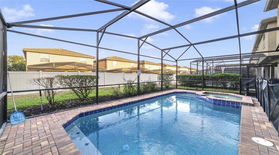 The HEATED IN-GROUND POOL AND SPA, enclosed within a screened lanai, promise year-round enjoyment.