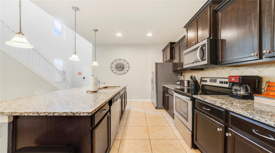 The open-concept Kitchen anchors the home with a functional layout, including an abundance of solid wood cabinets and stone countertops.