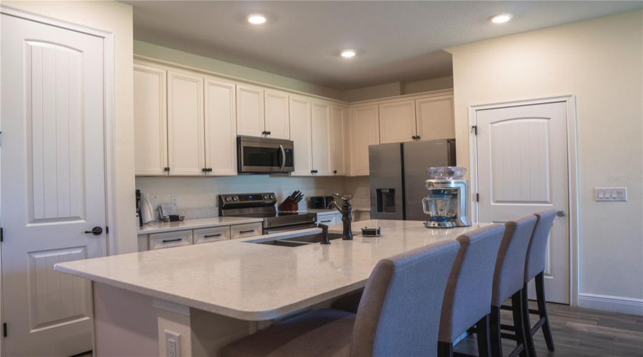 Spacious modern kitchen with stainless steel appliances, large island, and bright cabinetry — perfect for cooking and entertaining in your Margaritaville getaway.