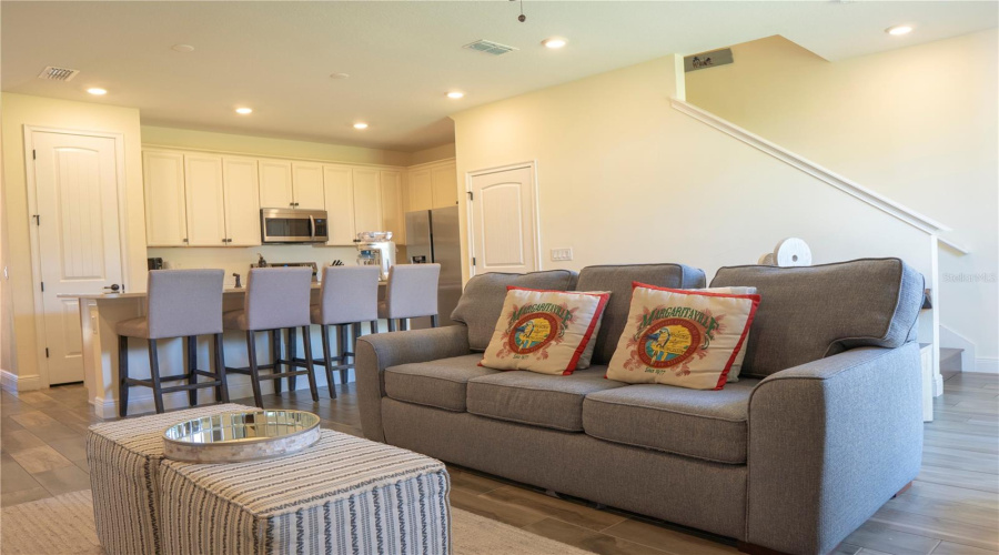 Relax in this inviting living area with Margaritaville flair and direct access to the modern kitchen — perfect for family gatherings or vacation stays.