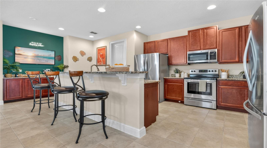 A Chef's Kitchen with Granite Counters and Breakfast Bar with Ample Seating