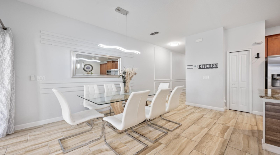 The Dining area is highlighted by a contemporary light fixture and decorative wall detail.