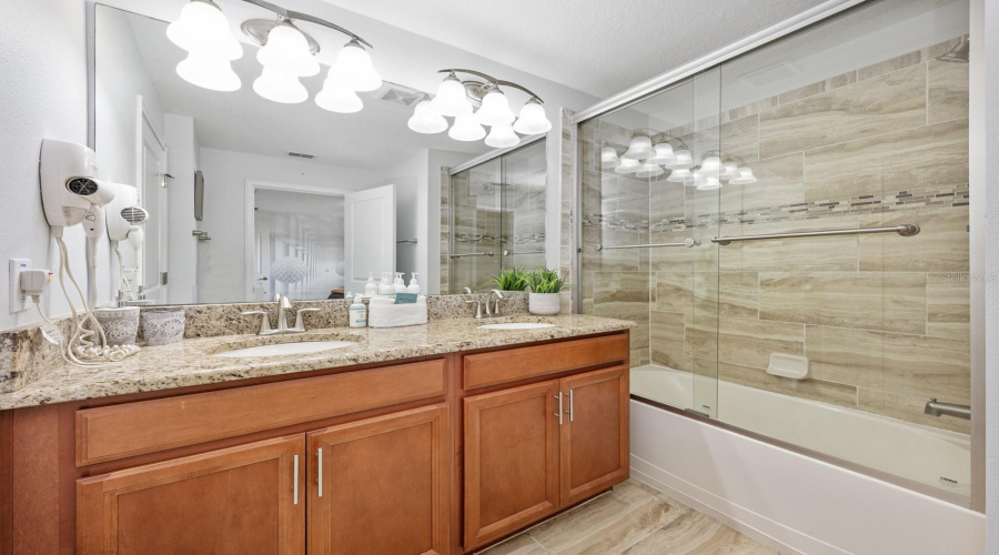 The Primary EN SUITE BATH features dual sinks, a tub/shower with glass enclosure, and a private water closet.