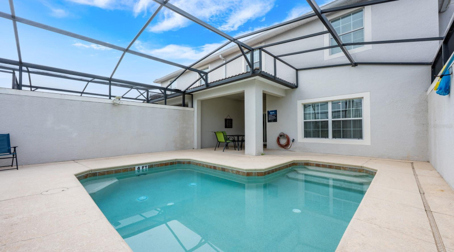Sliding glass doors lead to the covered rear porch and screened lanai, where your PRIVATE IN-GROUND POOL creates the ultimate indoor-outdoor retreat.