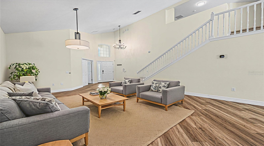 Living room with view of the foyer and stairway - virtually staged