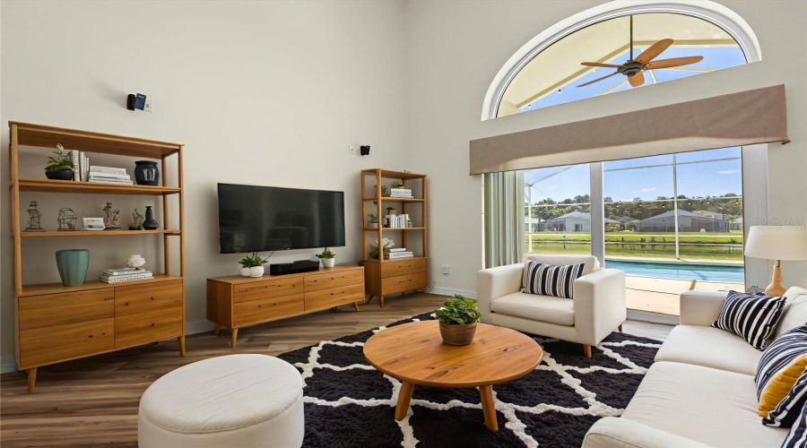 Family room with view of pool and water - virtually staged