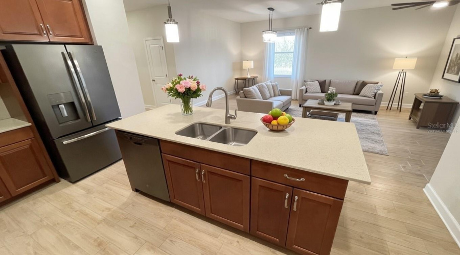 Virtually staged kitchen looking out upon living room