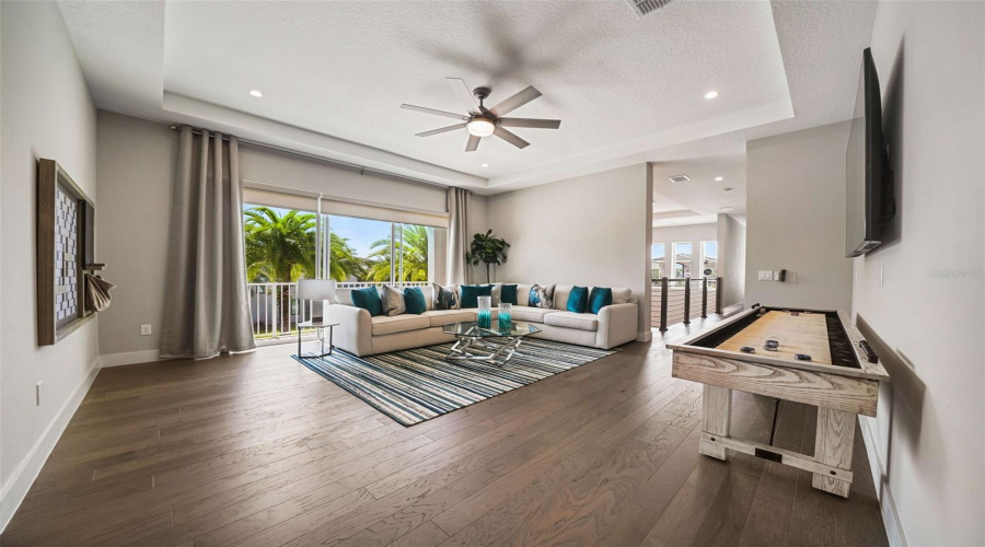 Designed for entertainment, the home includes a game room and a private theater with tiered seating, projection screen, ceiling-mounted projector, and surround sound, delivering an authentic in-home cinema experience.