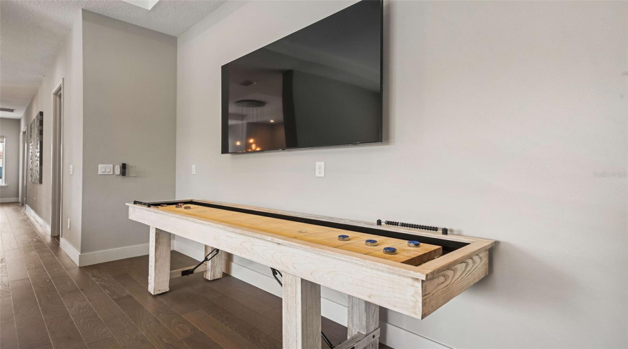 Designed for entertainment, the home includes a game room and a private theater with tiered seating, projection screen, ceiling-mounted projector, and surround sound, delivering an authentic in-home cinema experience.