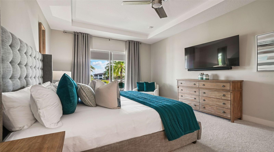 The upstairs primary bedroom features a private balcony overlooking the resort-style backyard, an ensuite bathroom with dual vanities, a separate soaking tub, a walk-in shower, and a spacious walk-in closet.