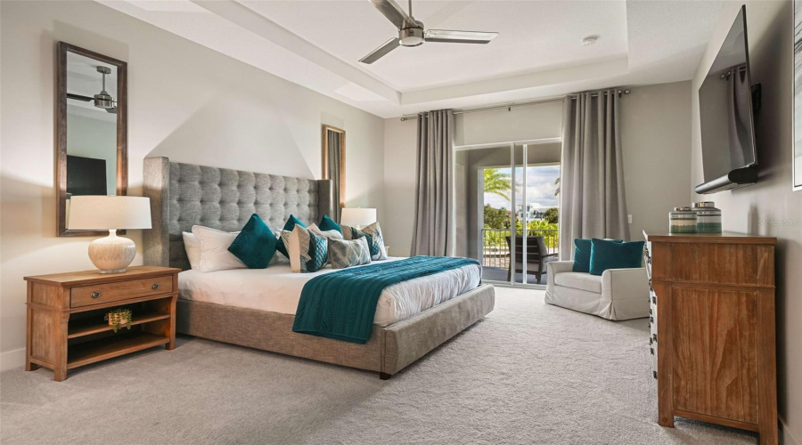 The upstairs primary bedroom features a private balcony overlooking the resort-style backyard, an ensuite bathroom with dual vanities, a separate soaking tub, a walk-in shower, and a spacious walk-in closet.