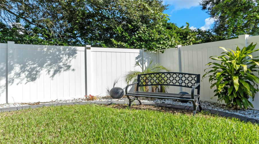 Fully fenced in backyard Featuring bench.
