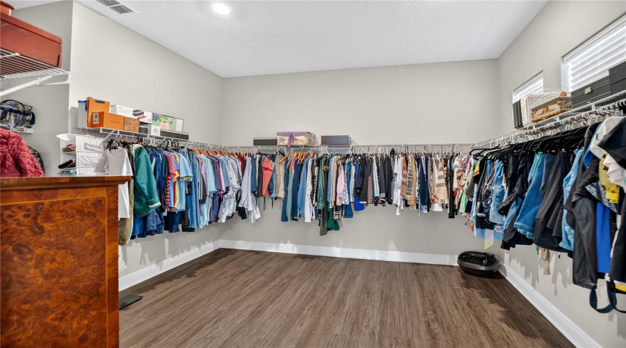 Large walk-in closet with built-in shelving and hanging space.