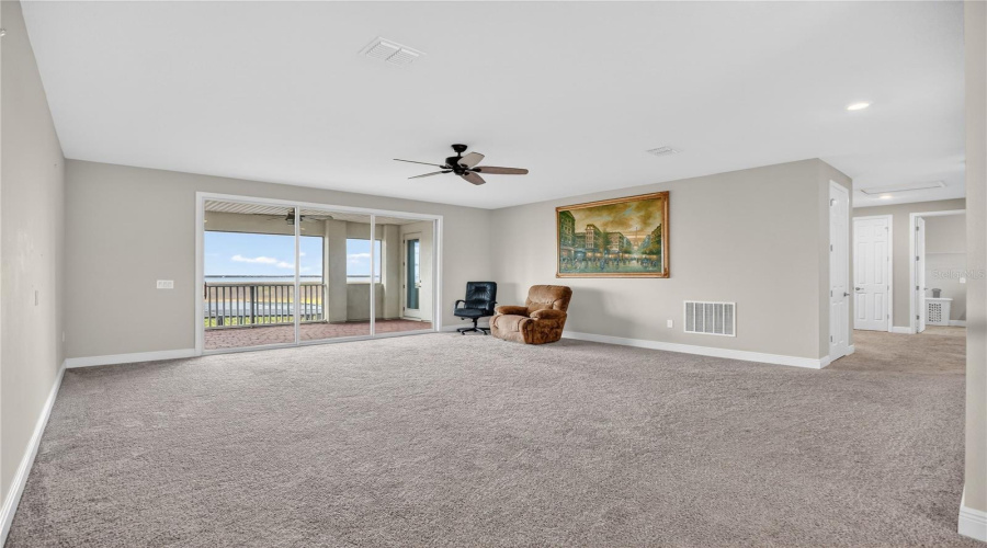 Large upstairs loft with carpet flooring and flexible layout.