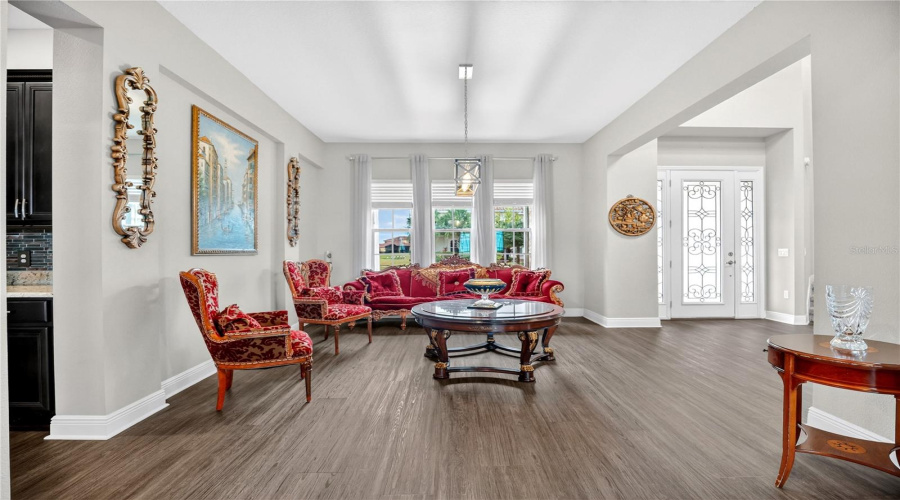 Alternate angle of the formal living area showing natural light and front entry.
