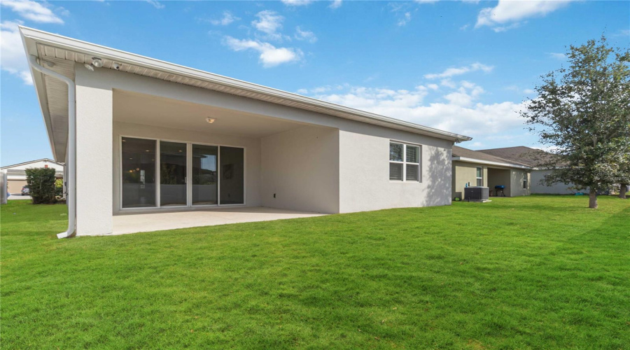 Large covered lanai area with virtually staged grass
