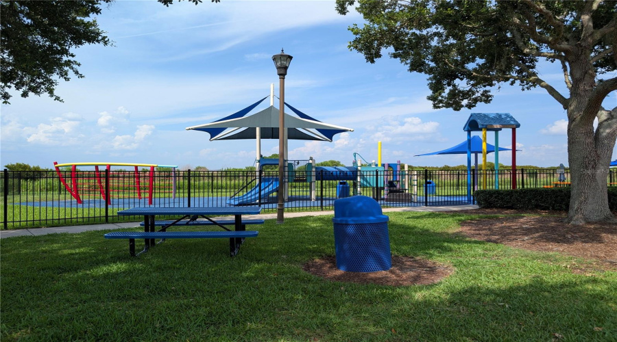 Picnic bench in the shade next to the playground.
