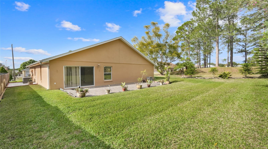 The backyard has ample space for various outdoor activities.