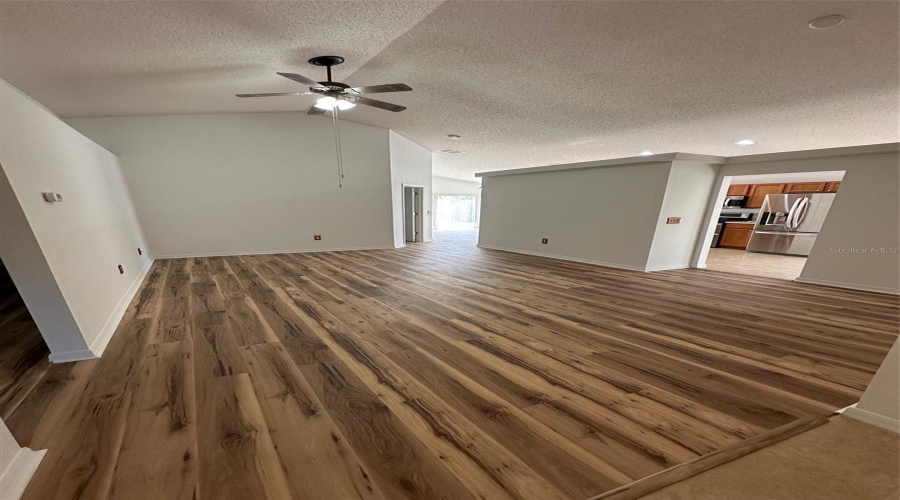 The living room splits the home between the primary suite and bedrooms 2 and 3.