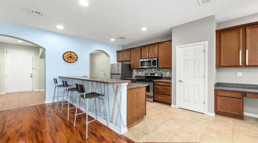 View of Front Entry / Kitchen area.  Door opens to pantry.  Built in desk area to the Right.