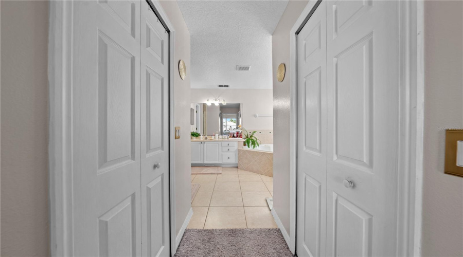 Primary bathroom entrance, his and her closets.