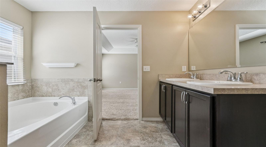 Primary Bath with dual vanity at comfort height with large cabinets for additional storage