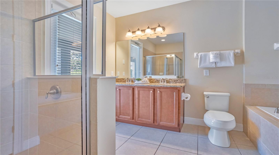 Private ensuite bath with granite countertops and glass-enclosed shower