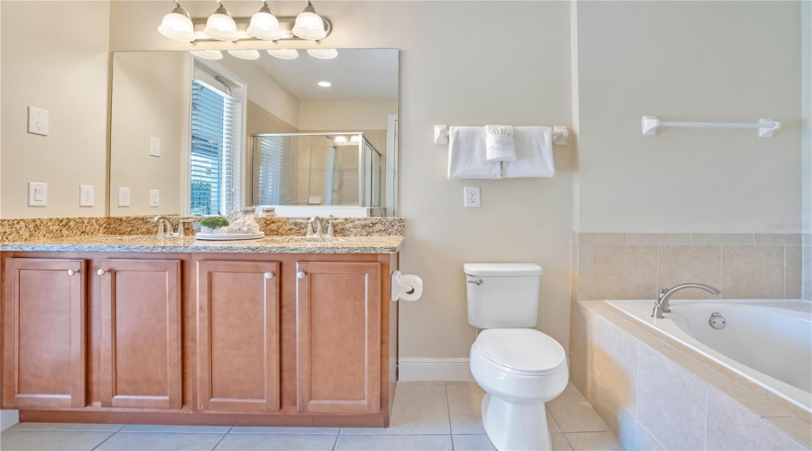 Bright, well-appointed bathroom offering generous vanity space and modern finishes with Access to Lanai and Pool Area